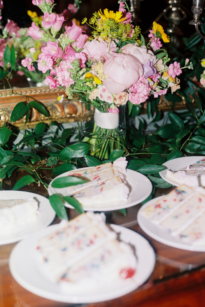 35mm film wedding detail image of sliced cake with floral arrangements