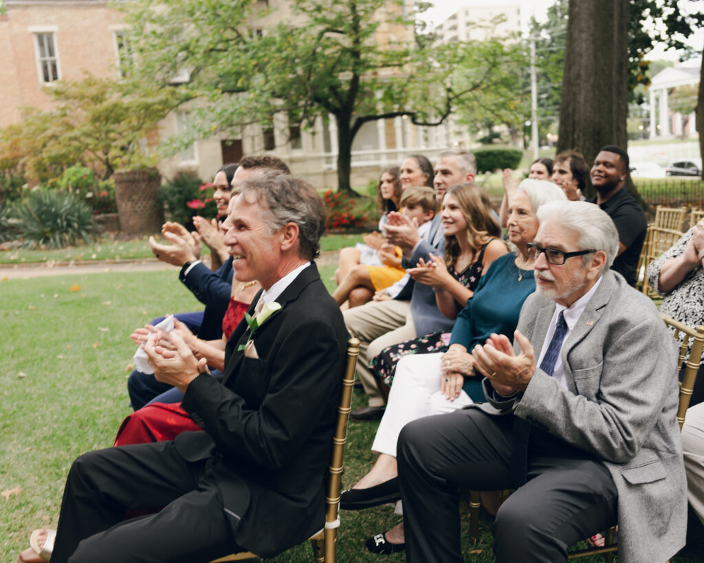 Wedding guests crowd cheering and celebrating after the first kiss