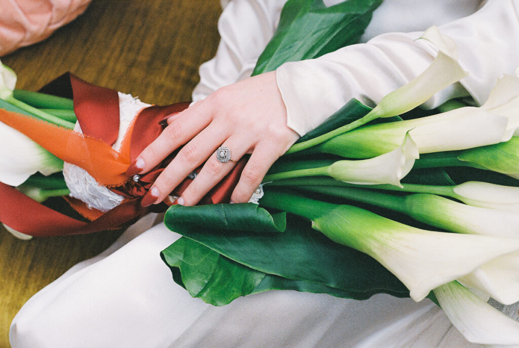 vintage art deco wedding inspiration of bride's hands with calla lilly bouquet and vintage wedding ring